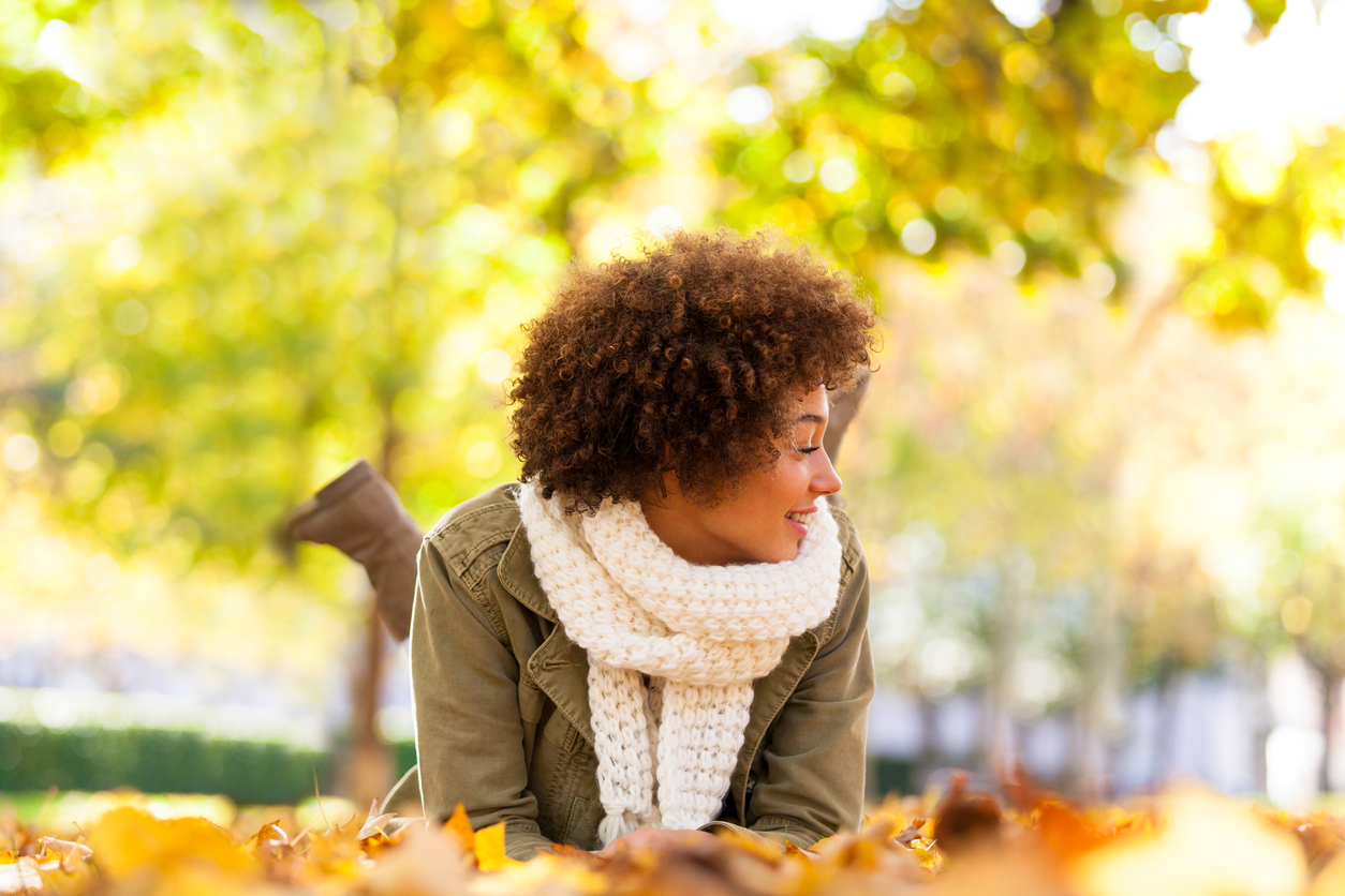 Woman pausing in the fall leaves represent Self-Improvement Month