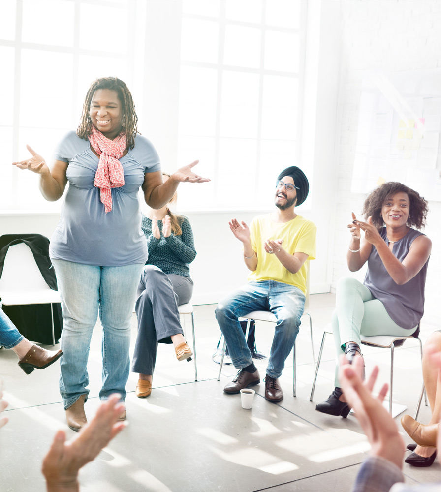 woman standing in front of clapping group