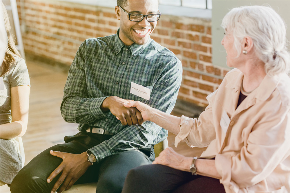 man and woman shaking hands seated