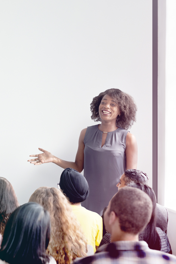 woman speaking in front of group