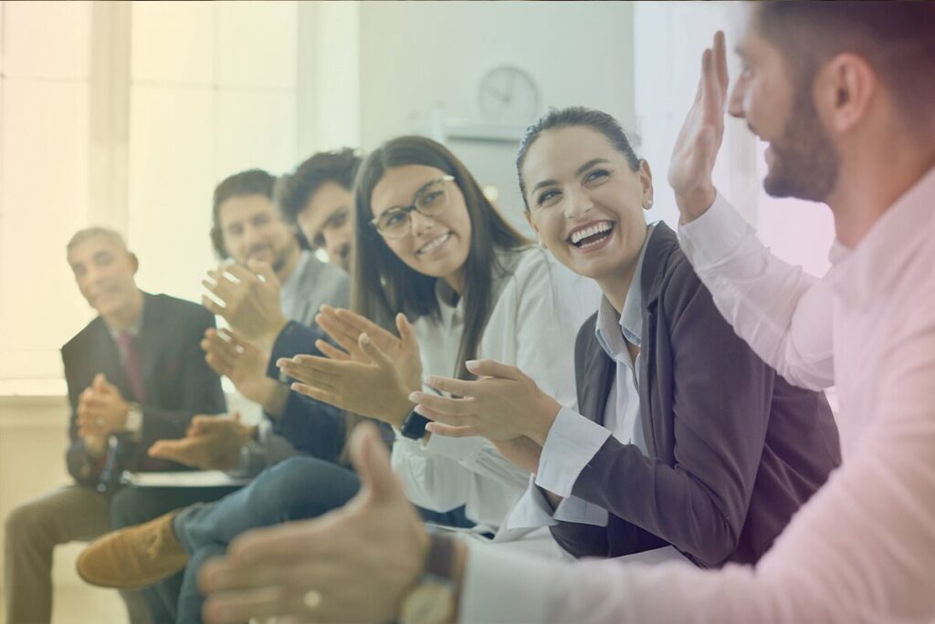 A business team cheers as they learn how workplace coaching can boost organizational performance.