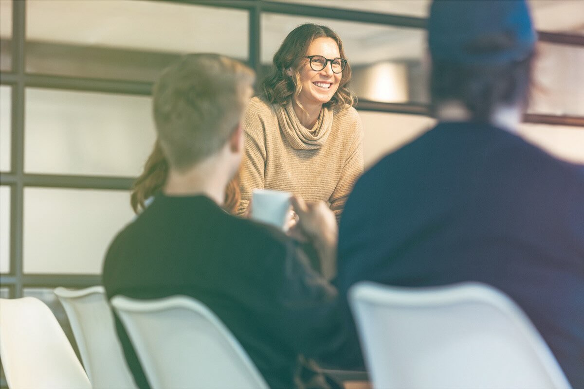 A woman confidently leads a group of peers.