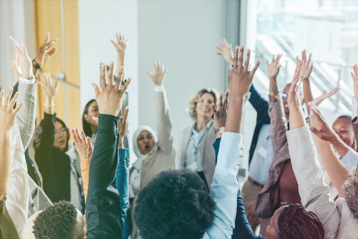 Business professionals raising their hands.