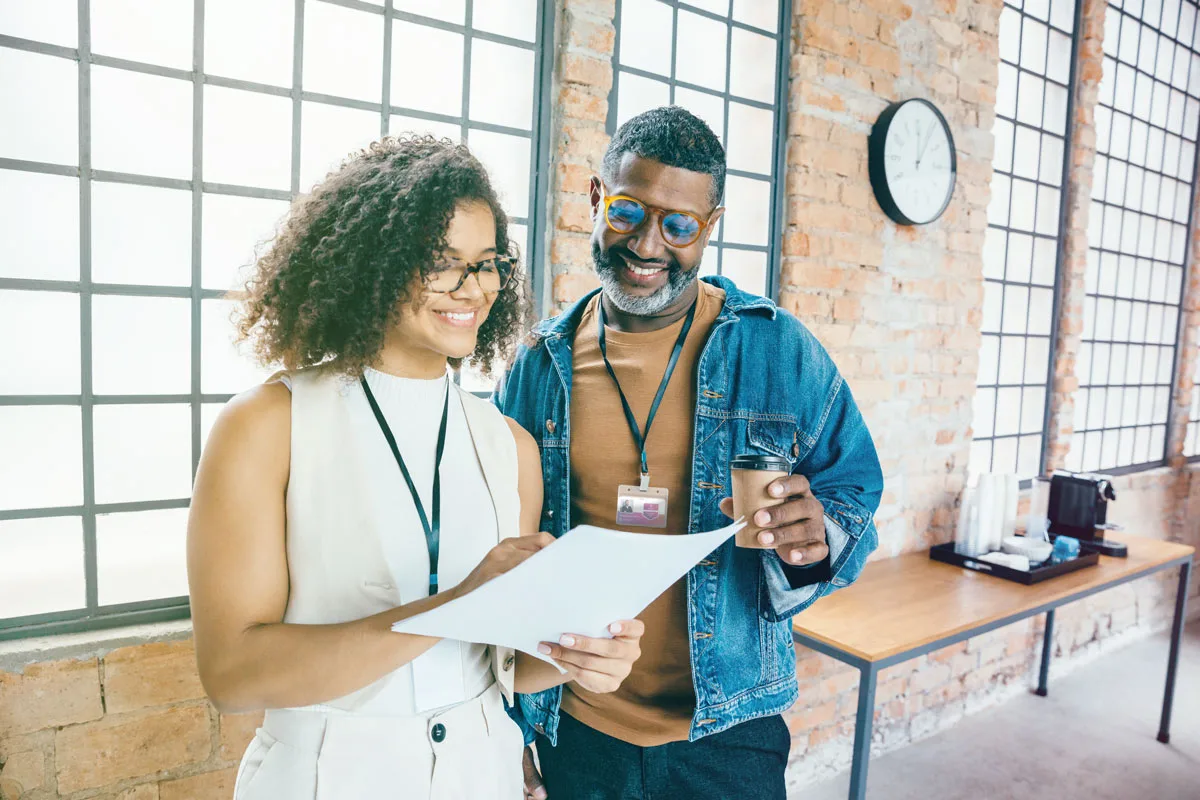 Two professionals reviewing document together in office setting Two professionals reviewing document together in office setting
