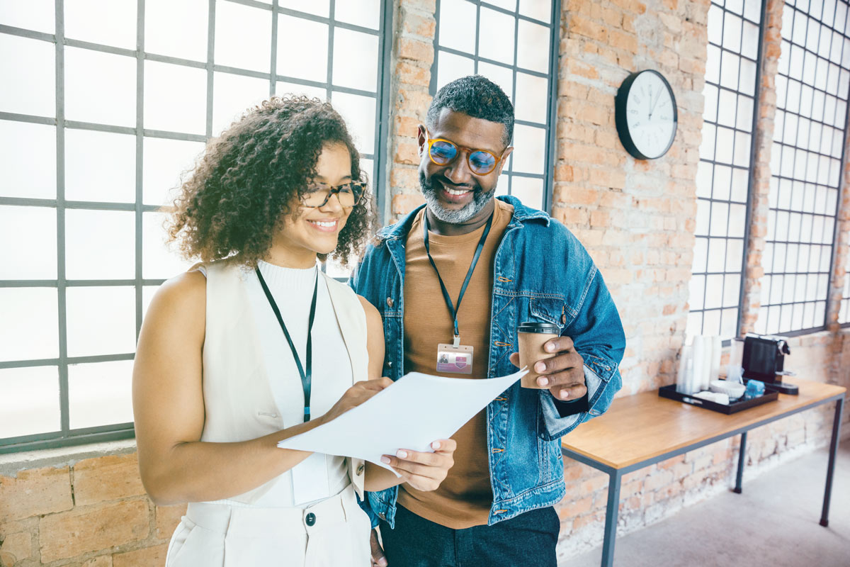 Two professionals reviewing document together in office setting
