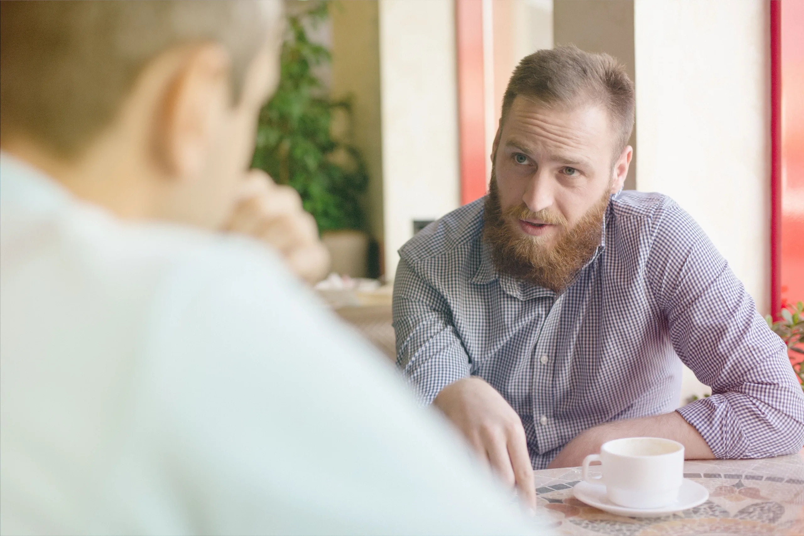 Coach listening attentively during one-on-one conversation over coffee