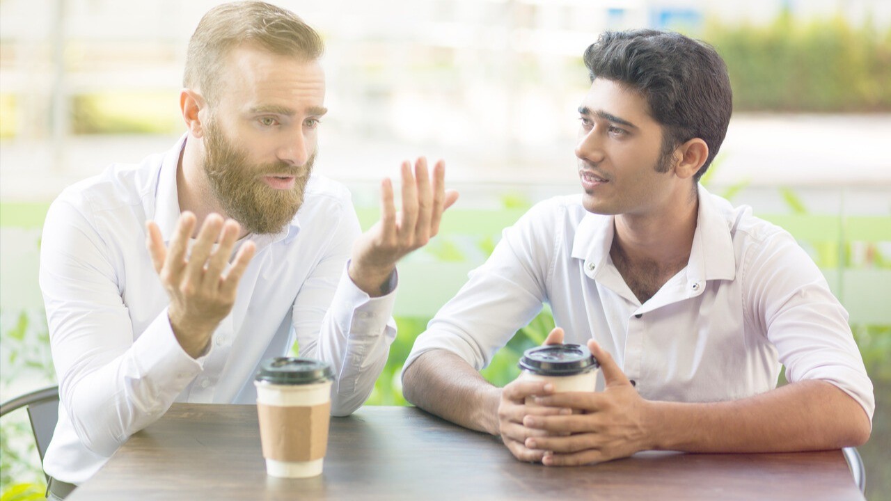 Two men talking with coffee. Main image for trust through coaching article.
