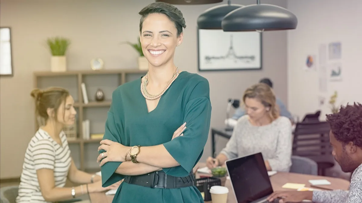 1772806360802 Woman standing in foreground with team behind her. Main image for article about why the body matters in coaching