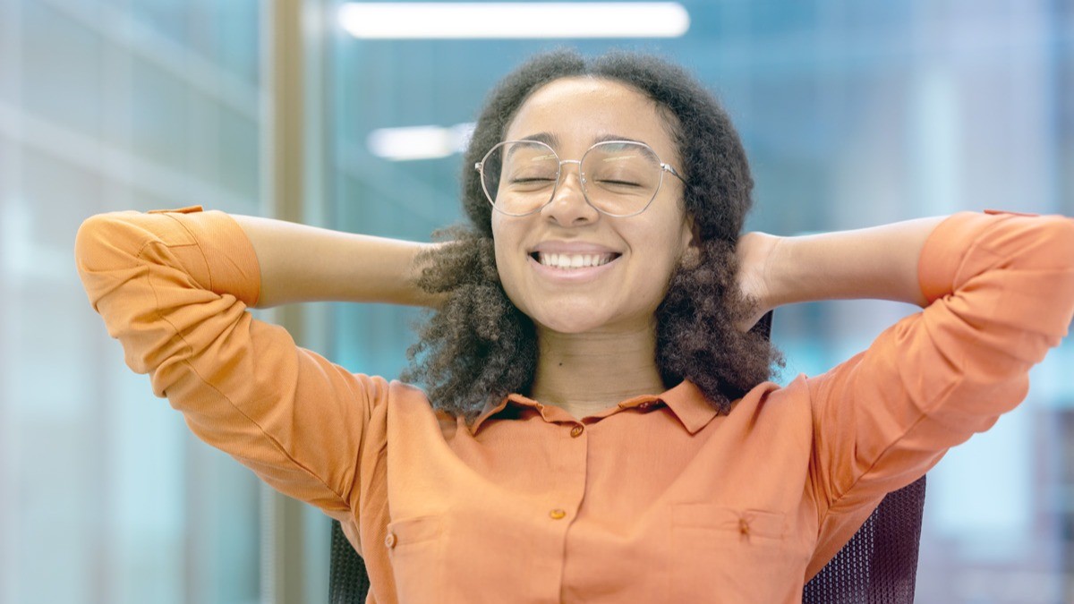 Woman leaning back in orange long-sleeve shirt; main image for neuroscience article