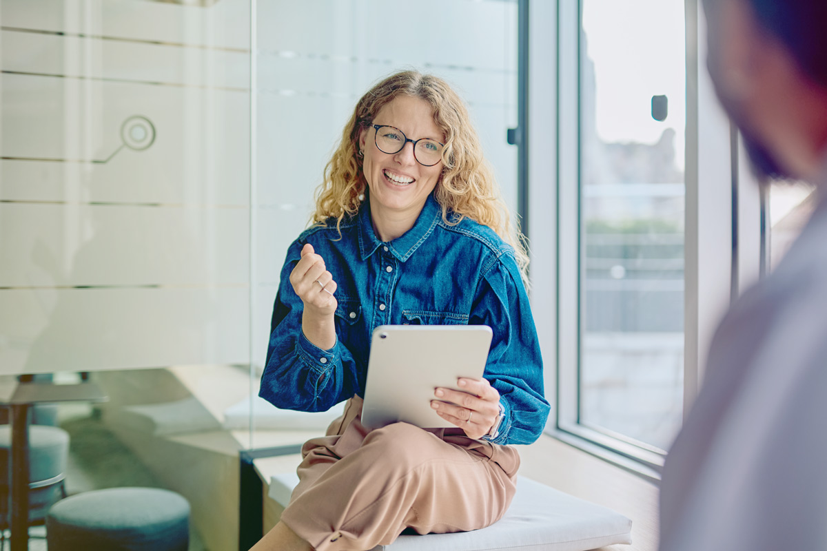 Lady in blue shirt holding a tablet