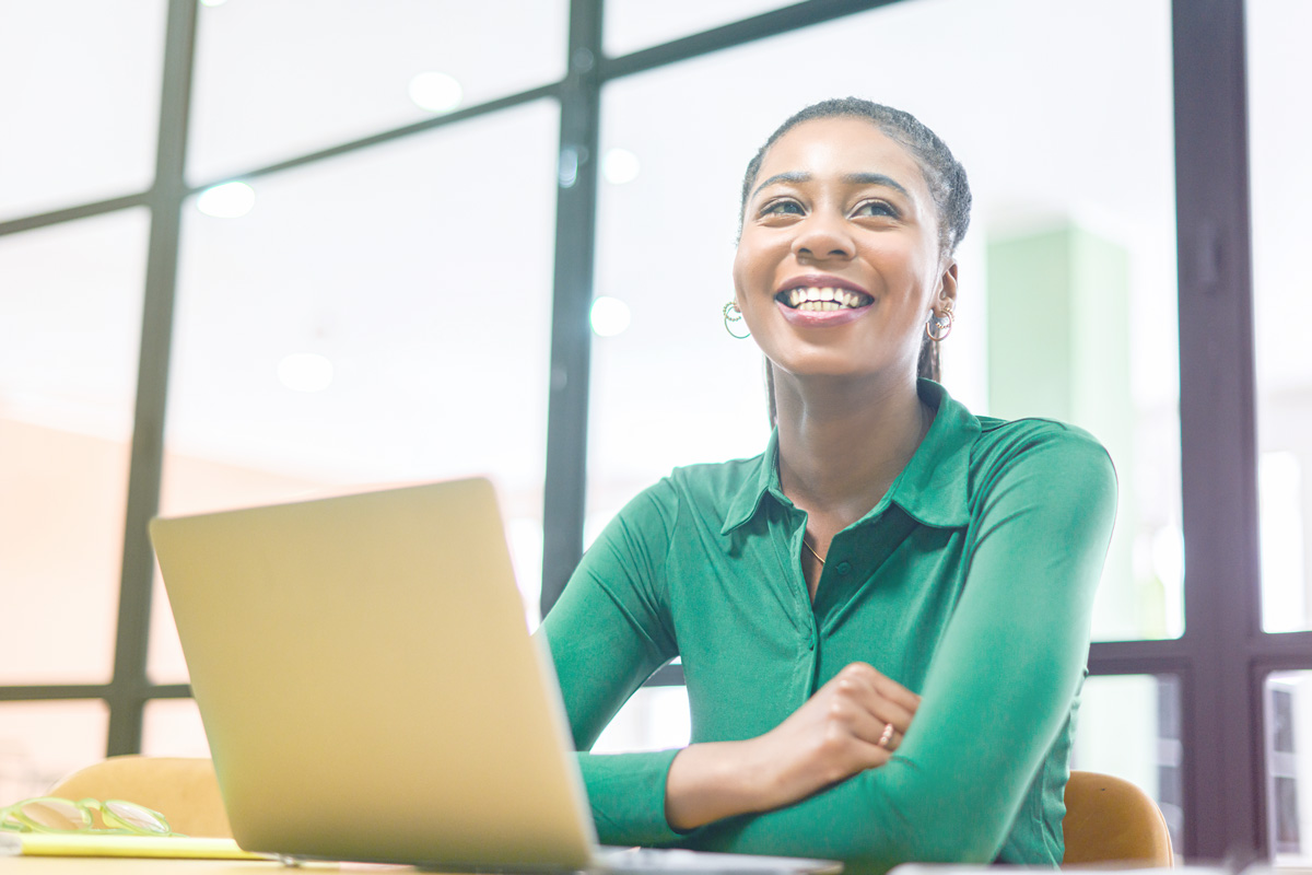 Smiling lady in green with a laptop