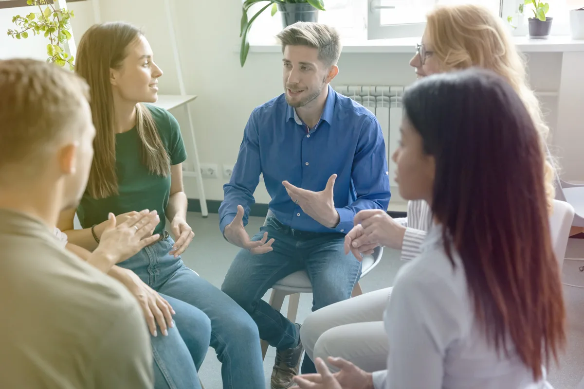 Group of people sitting in a circle having a discussion