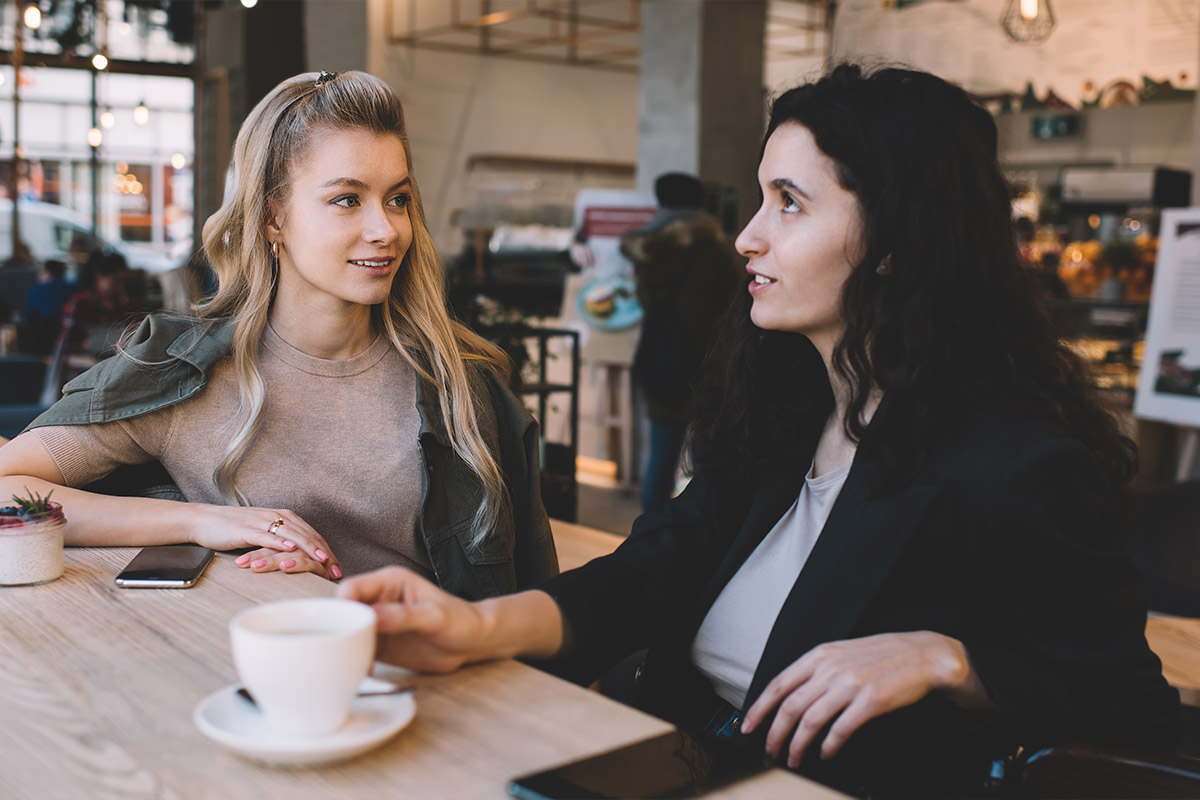 Two women having a conversation over coffee in a cafe
