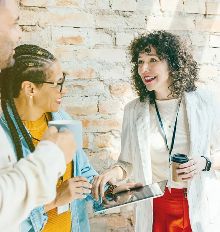 Woman in group talking, badges on lanyards around their necks.