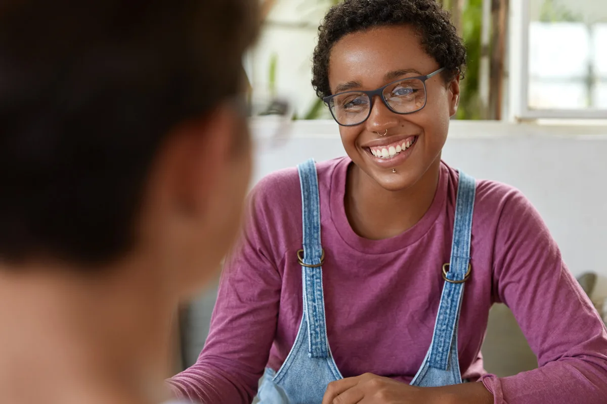 Person smiling during a one-on-one conversation.