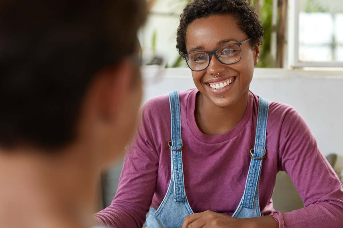 Person smiling during a one-on-one conversation.