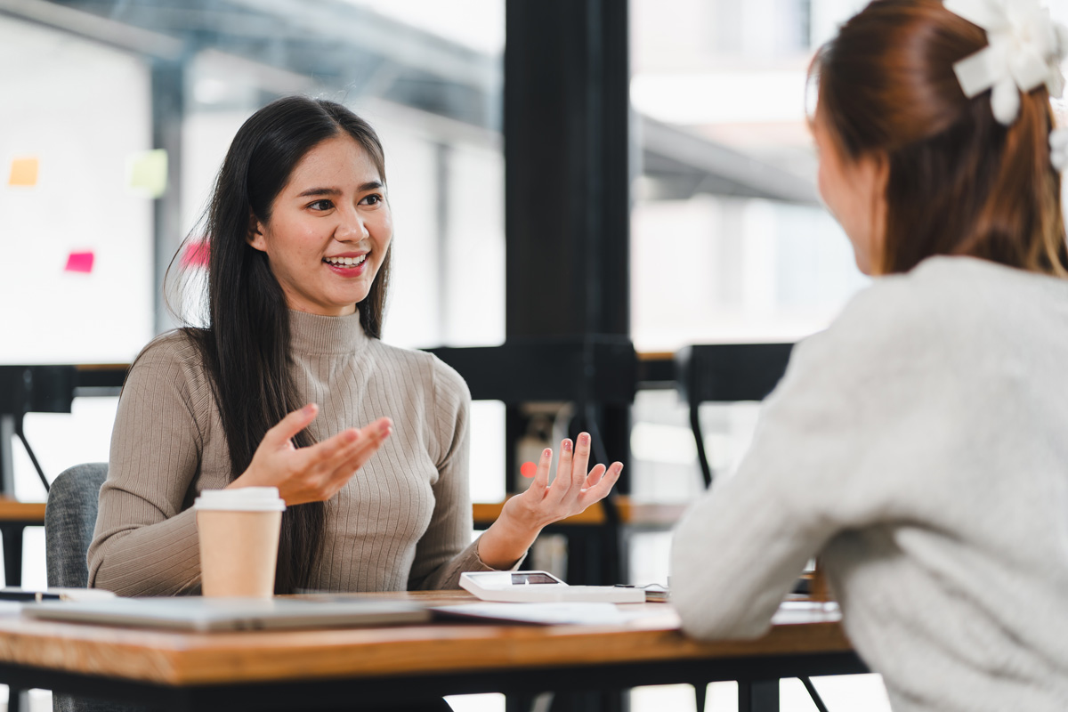 Two people having a coaching conversation across a table.