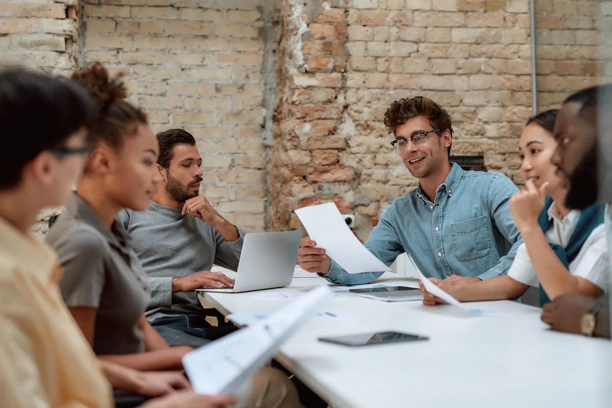 Team members discussing documents during a meeting.