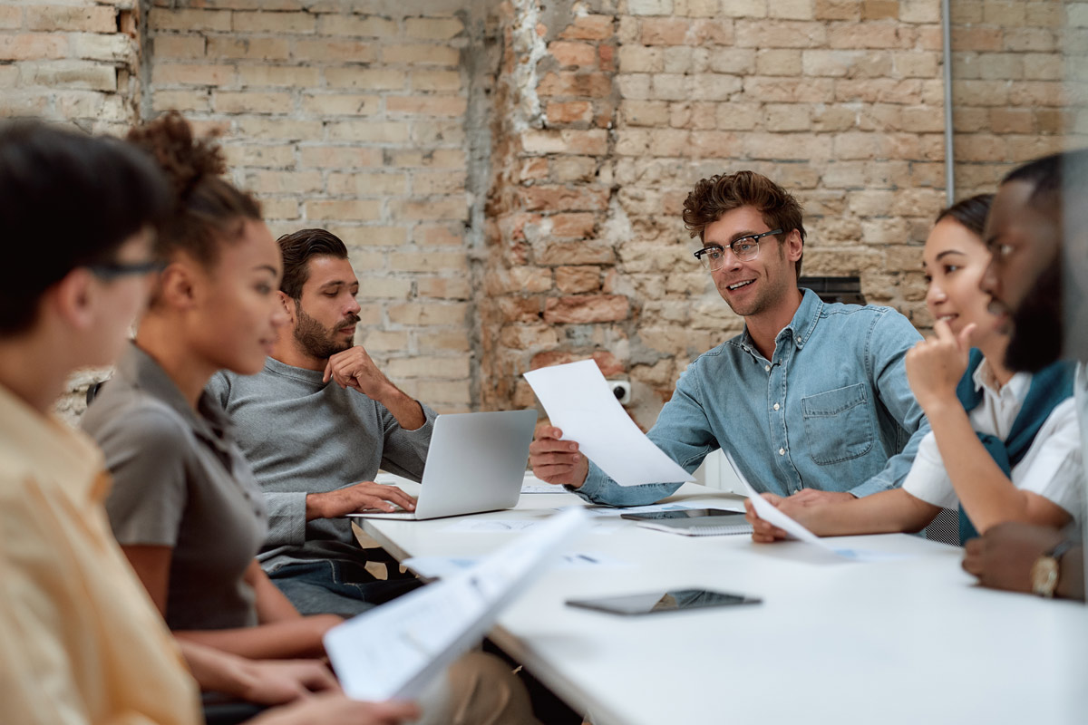 Team members discussing documents during a meeting.