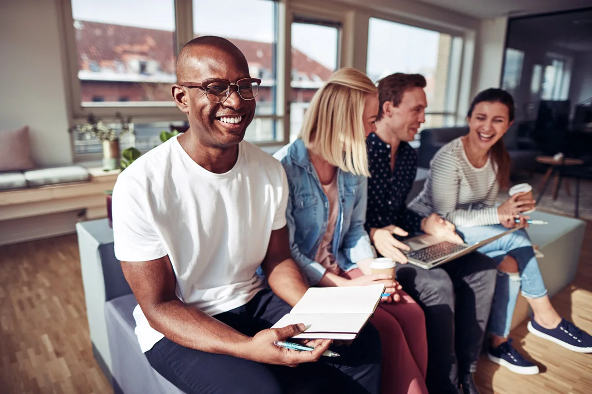 Team members smiling together during a workplace meeting.