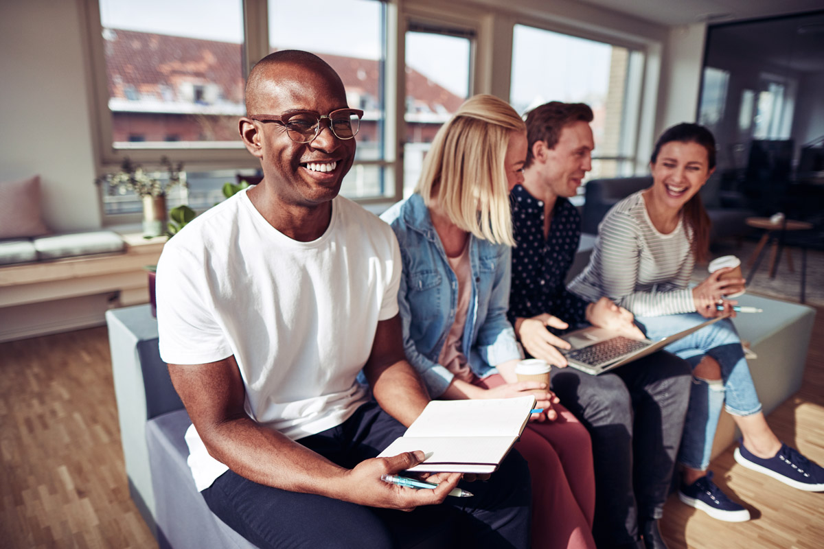Team members smiling together during a workplace meeting.