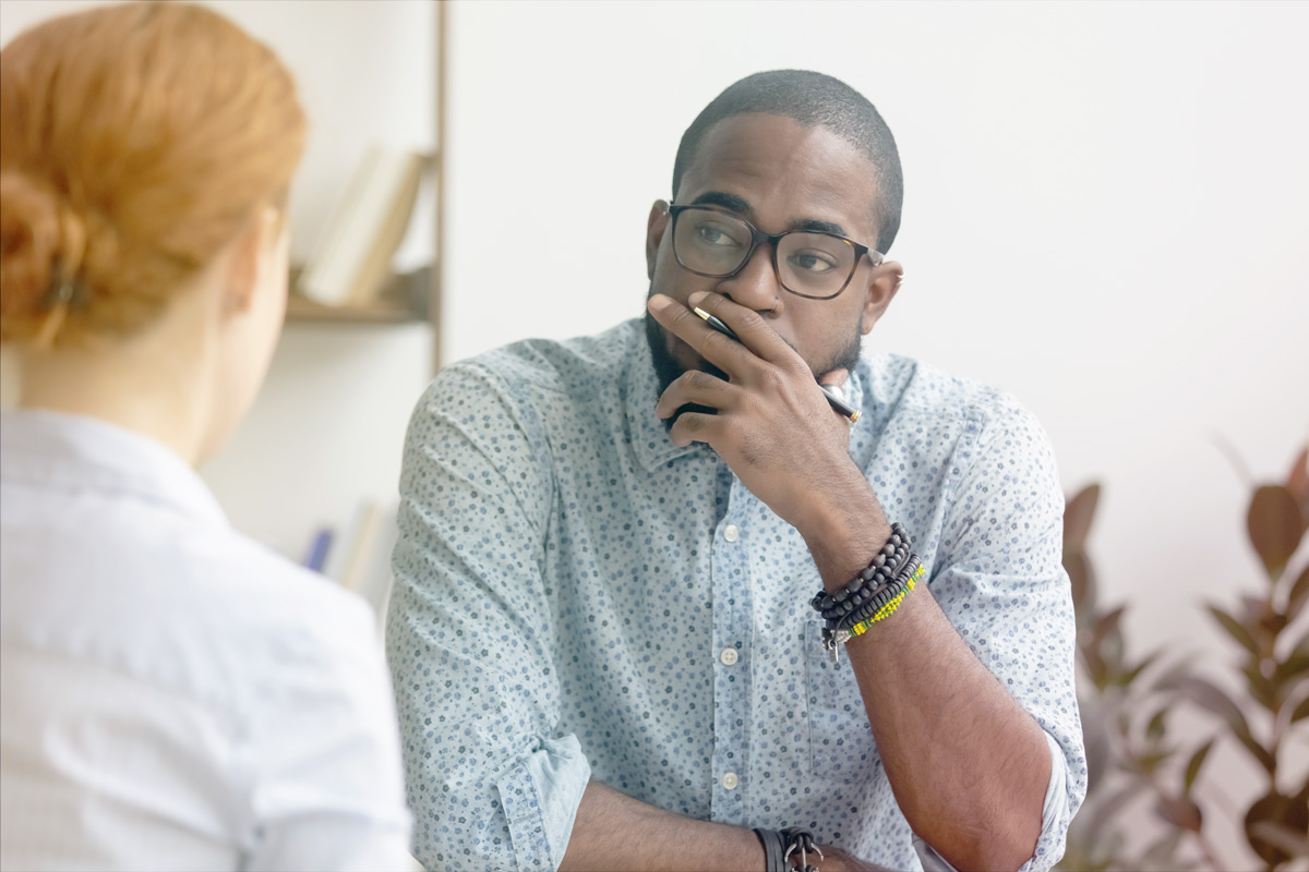 Man listening while holding a pen during a conversation.