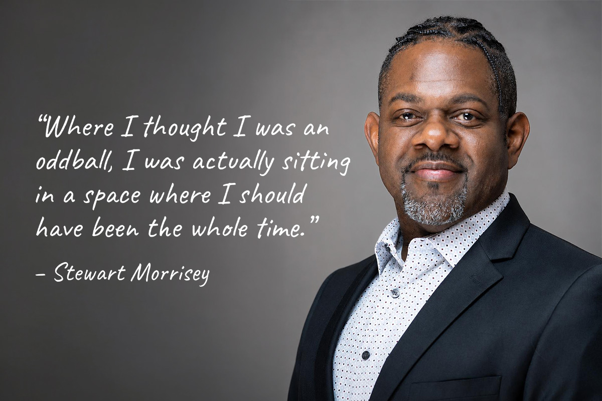 A man smiling in front of a quote graphic.