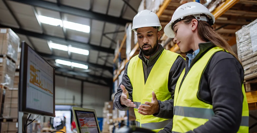 Two workers discussing in warehouse
