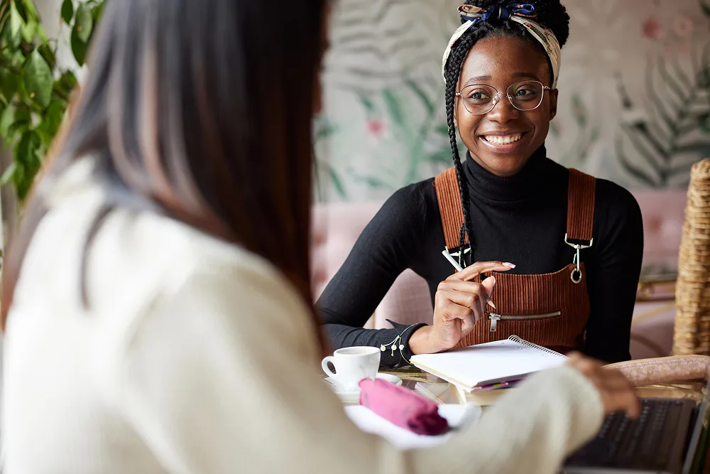 Two women chatting in a cafe.