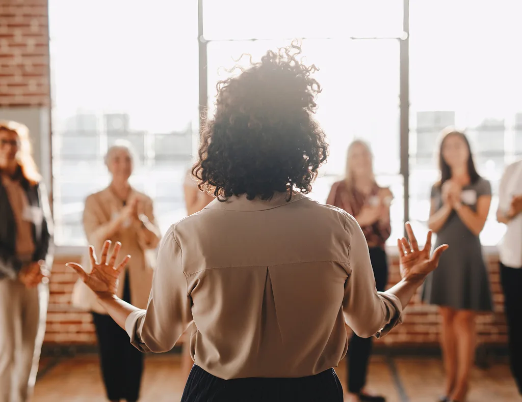 Woman speaking to an applauding audience